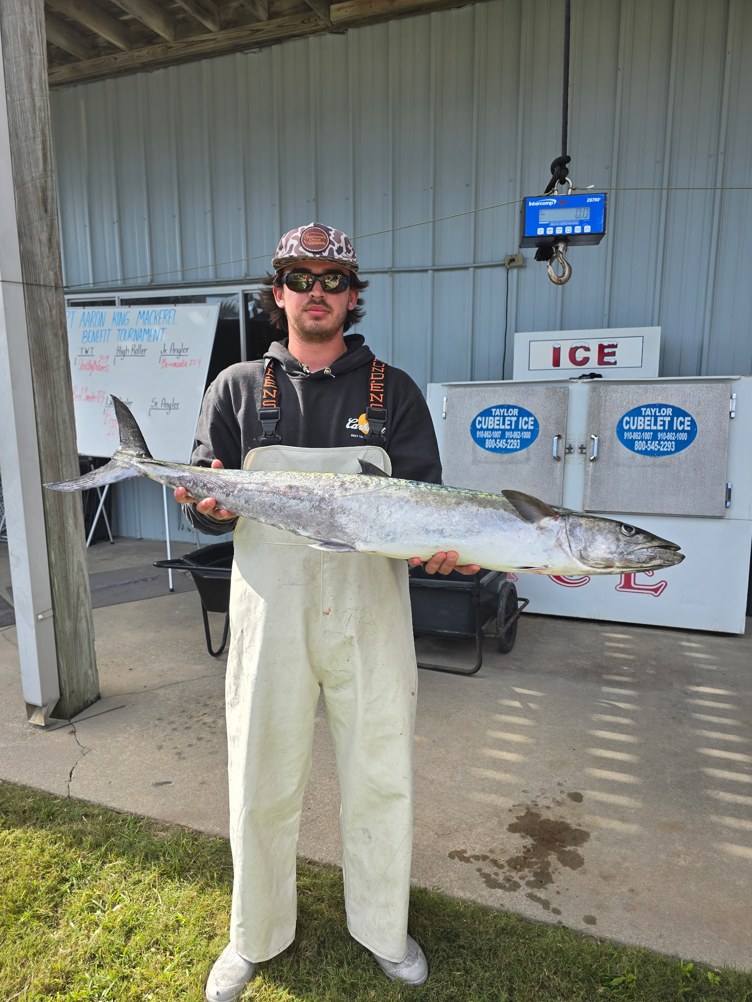Angler holding king mackerel at weigh-in